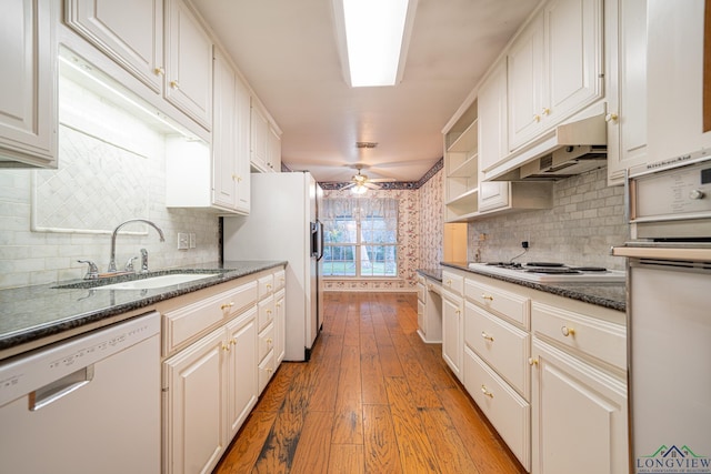 kitchen featuring light wood-type flooring, premium range hood, white appliances, sink, and white cabinets