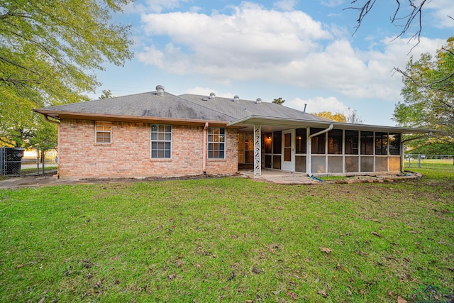 back of house featuring a lawn and a sunroom