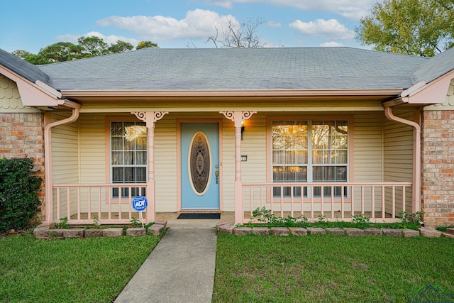 property entrance featuring a porch and a yard