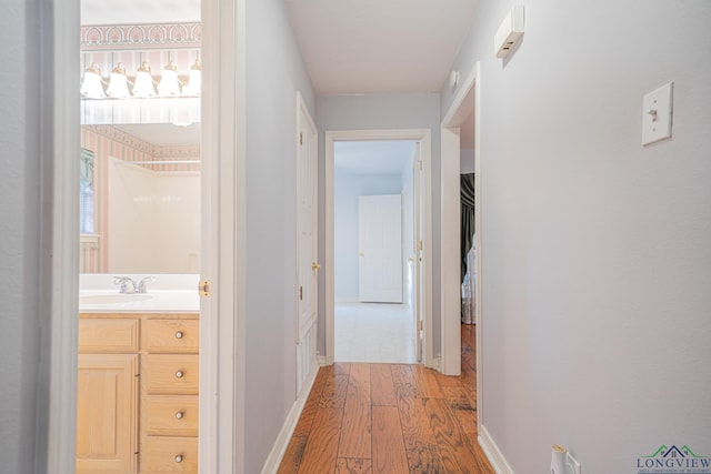 hall with sink and light hardwood / wood-style floors