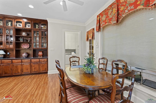 dining area featuring ceiling fan, ornamental molding, light wood-type flooring, and separate washer and dryer