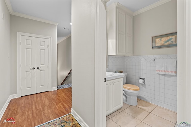 bathroom with tile walls, toilet, vanity, and crown molding