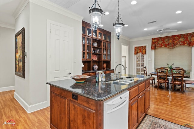 kitchen featuring ornamental molding, a center island with sink, hanging light fixtures, and white dishwasher