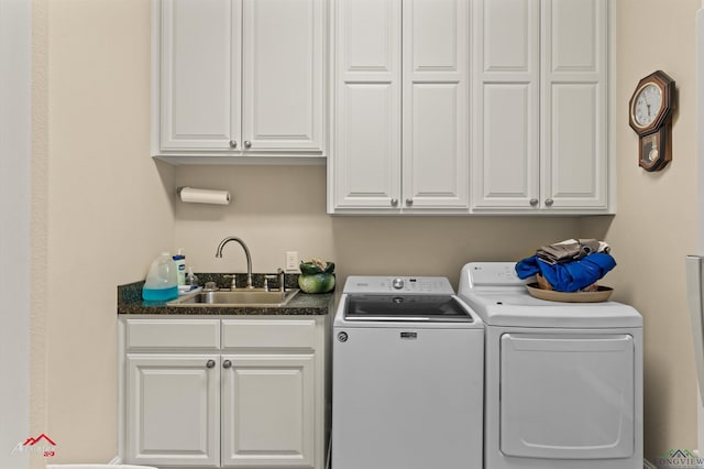 washroom featuring sink, separate washer and dryer, and cabinets