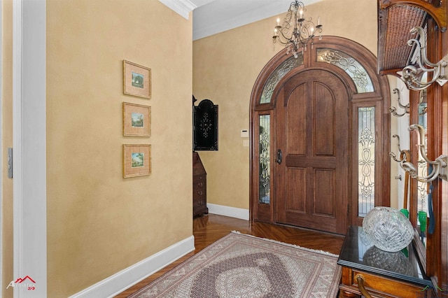 foyer entrance featuring ornamental molding, a chandelier, and a high ceiling