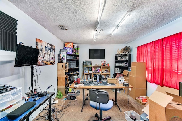 home office with a textured ceiling, carpet floors, and a workshop area