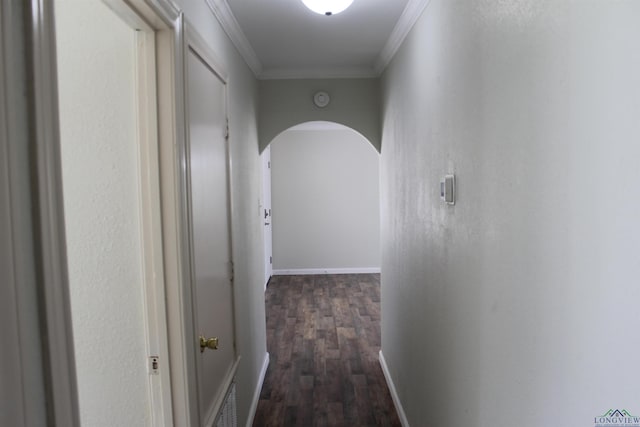 hall with dark wood-style floors, arched walkways, visible vents, ornamental molding, and baseboards