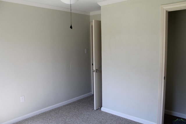 carpeted spare room featuring ornamental molding and baseboards