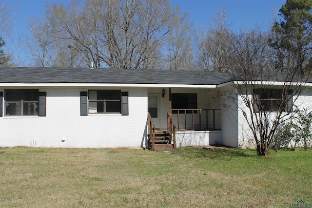 view of front of home featuring roof with shingles, brick siding, crawl space, and a front yard