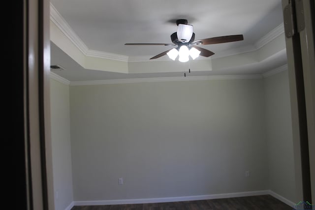 spare room with baseboards, a tray ceiling, and dark wood-style flooring