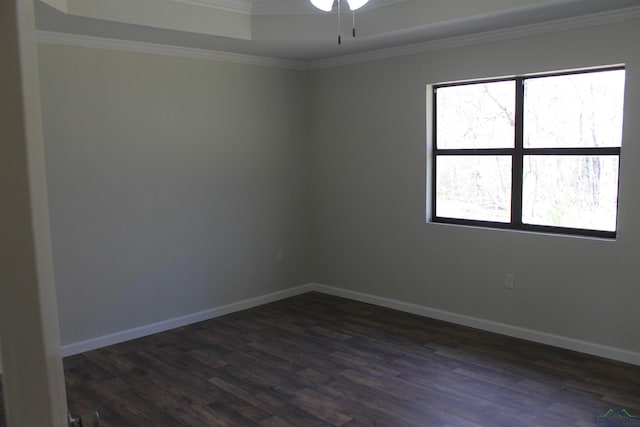 spare room with ornamental molding, dark wood-style flooring, a ceiling fan, and baseboards