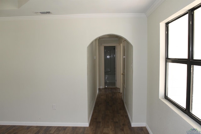 hall featuring arched walkways, crown molding, visible vents, and a healthy amount of sunlight