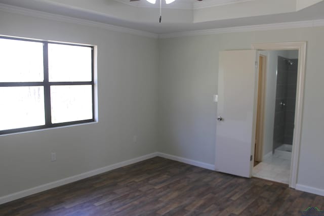 unfurnished room with crown molding, baseboards, ceiling fan, and dark wood-style flooring