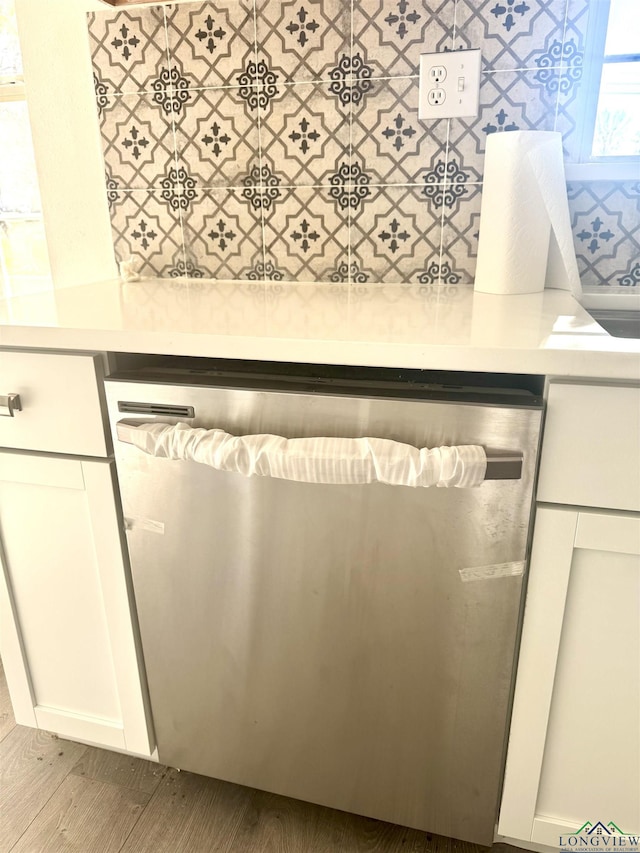 room details with white cabinets, dishwasher, light hardwood / wood-style floors, and hanging light fixtures