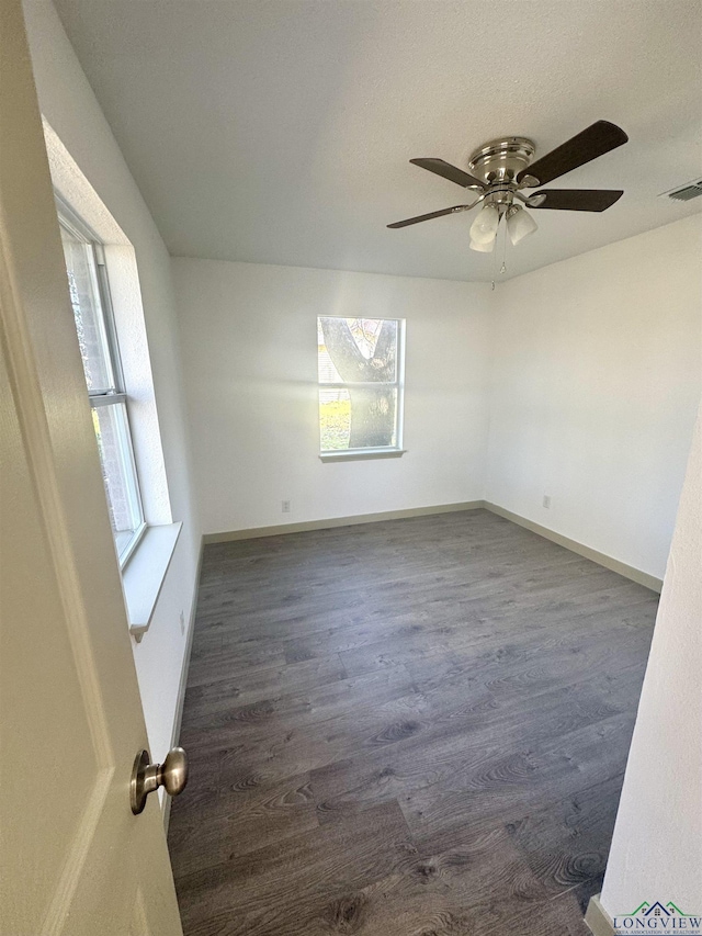 unfurnished room with dark hardwood / wood-style floors, ceiling fan, and a healthy amount of sunlight