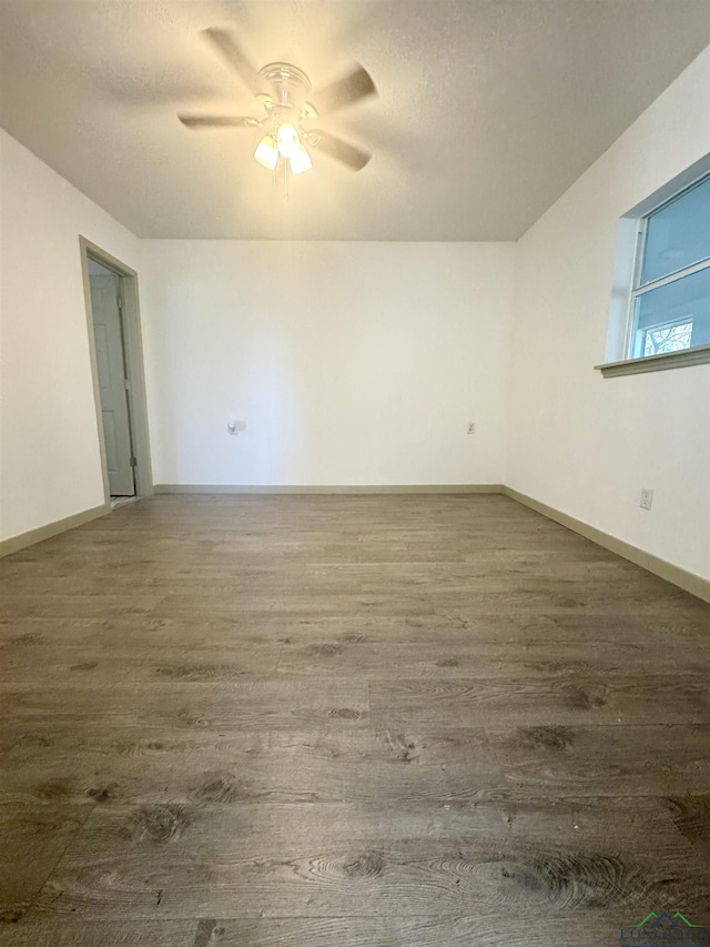 unfurnished room with ceiling fan and dark hardwood / wood-style flooring