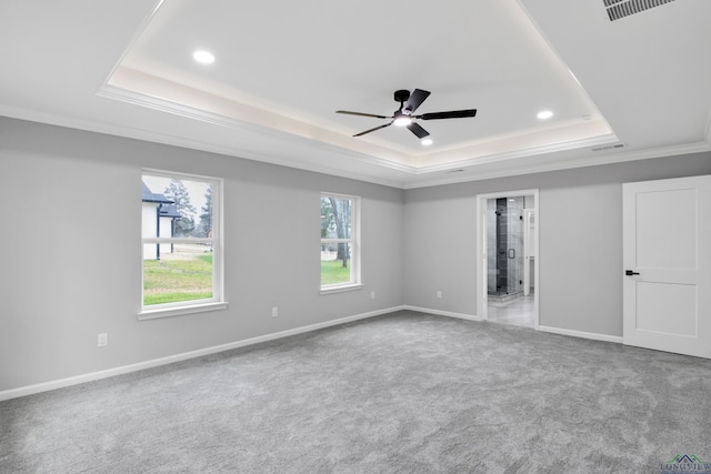 unfurnished bedroom featuring carpet flooring, visible vents, baseboards, ornamental molding, and a raised ceiling