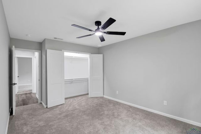 unfurnished bedroom featuring light colored carpet, ceiling fan, and a closet