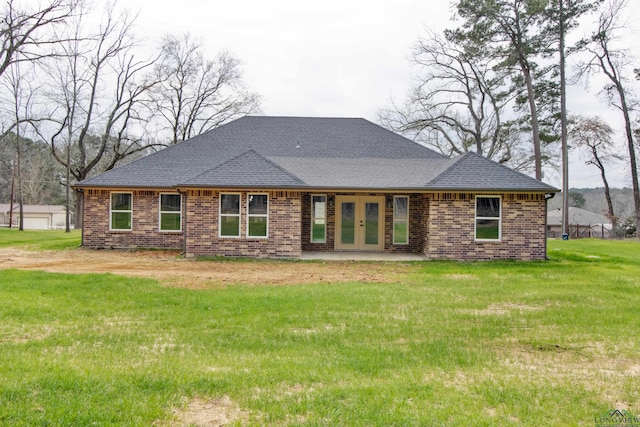 back of property featuring brick siding, a shingled roof, a lawn, and french doors