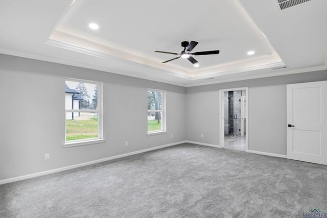 unfurnished bedroom with ceiling fan, carpet flooring, connected bathroom, ornamental molding, and a raised ceiling