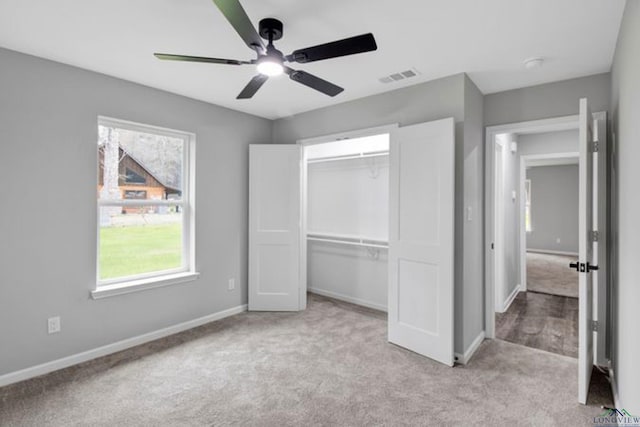 unfurnished bedroom with ceiling fan, light colored carpet, and a closet