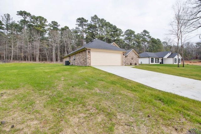 view of front of property with a garage, cooling unit, and a front lawn