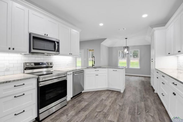 kitchen with sink, white cabinetry, decorative light fixtures, kitchen peninsula, and stainless steel appliances