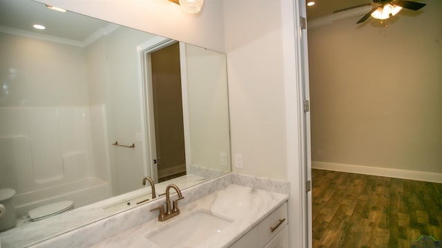 bathroom featuring ornamental molding, vanity, ceiling fan, wood-type flooring, and toilet