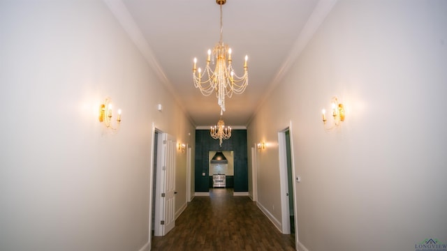 hall featuring ornamental molding, dark wood-type flooring, and a chandelier