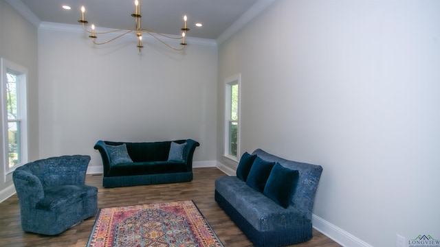 sitting room with dark hardwood / wood-style flooring, ornamental molding, and a chandelier