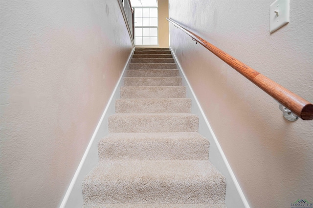 stairway featuring a textured wall