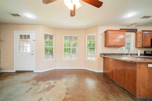 kitchen featuring ceiling fan, electric range, visible vents, and brown cabinets