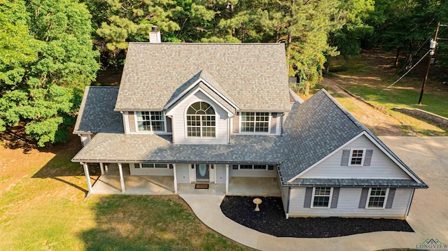 view of front of home featuring a front lawn, a patio area, and a chimney