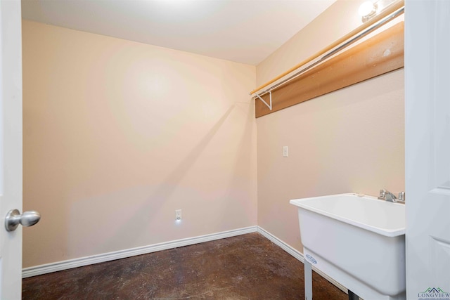 laundry area featuring baseboards and a sink