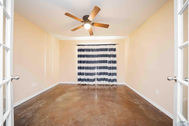 empty room featuring baseboards, a ceiling fan, and finished concrete flooring