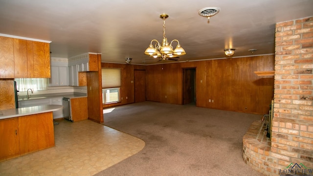 kitchen featuring a notable chandelier, decorative light fixtures, wood walls, and sink