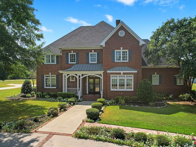 view of front of house featuring a front lawn, a porch, and french doors