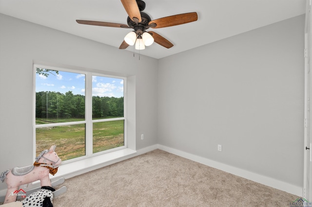 carpeted spare room featuring ceiling fan