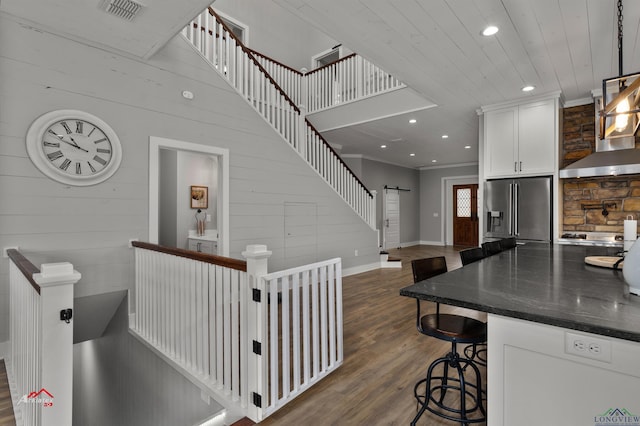 stairs featuring crown molding, wood ceiling, and hardwood / wood-style flooring