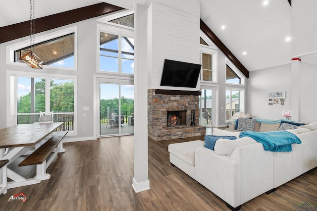 living room with a wealth of natural light, a fireplace, and high vaulted ceiling