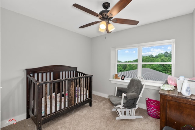 bedroom with carpet flooring, ceiling fan, and a nursery area