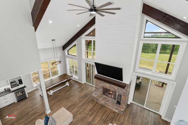 living room with beam ceiling, a fireplace, high vaulted ceiling, and dark wood-type flooring