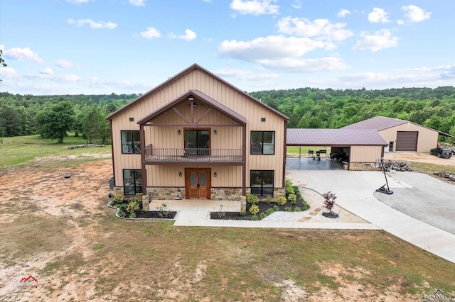 modern farmhouse style home with a carport, a balcony, and a front yard