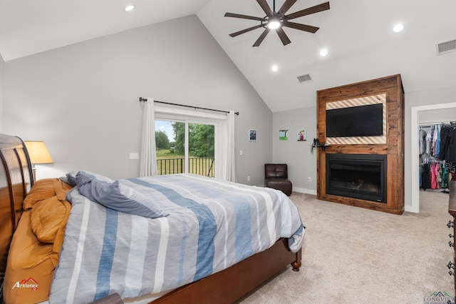 carpeted bedroom featuring access to exterior, ceiling fan, a spacious closet, a fireplace, and a closet