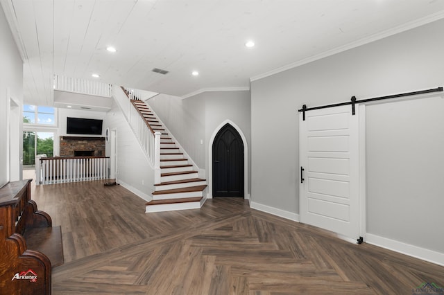 foyer entrance featuring dark parquet flooring, crown molding, and a barn door