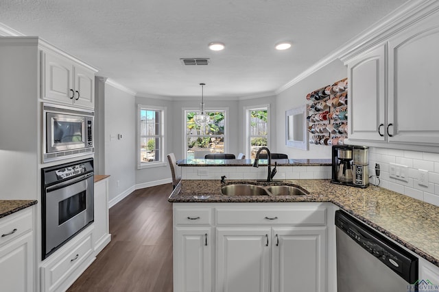 kitchen featuring appliances with stainless steel finishes, white cabinetry, crown molding, and sink