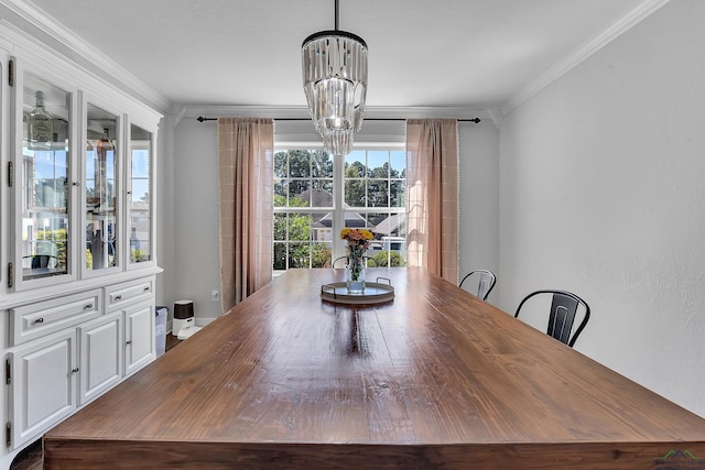 dining area with crown molding and a notable chandelier