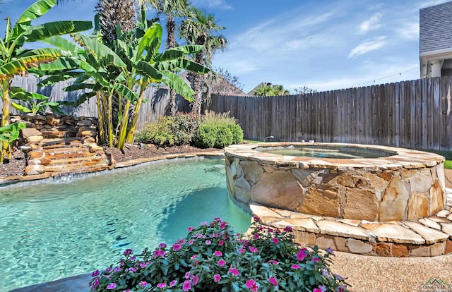 view of pool featuring an in ground hot tub and pool water feature