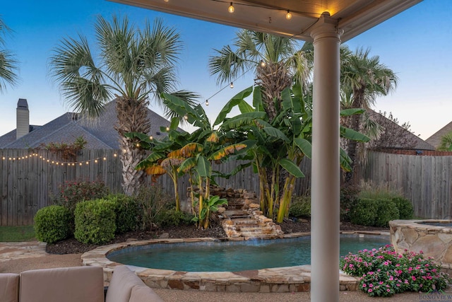 pool at dusk with pool water feature