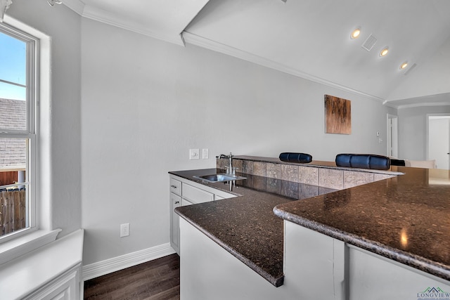 kitchen featuring kitchen peninsula, white cabinetry, sink, and dark wood-type flooring